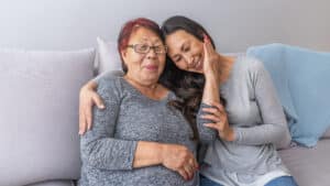 Happy Beautiful Older Asian Mother And Adult Daughter Embracing Looking At Camera Smiling Senior