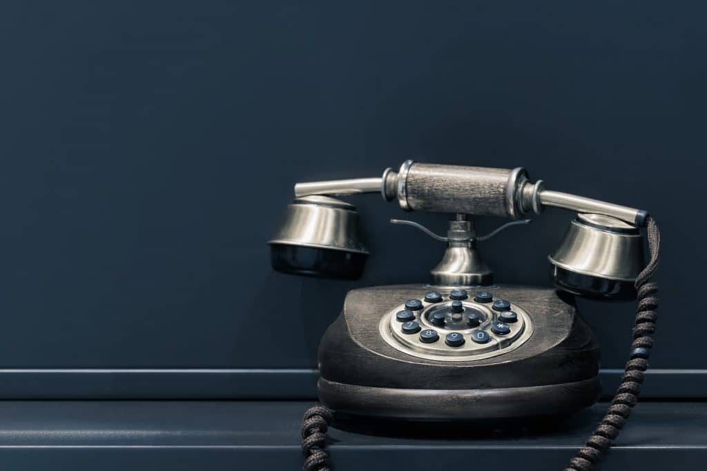 Black And Brown Rotary Phone Near Gray Wall